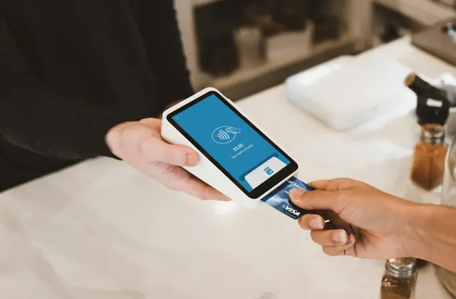 A guest paying by card in a warm cafe setting